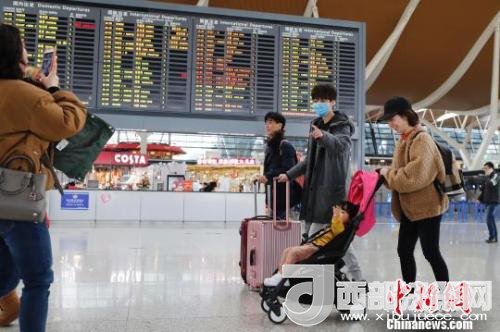 旅客帶著孩子前往辦票柜臺辦理登機手續(xù)。　殷立勤 攝