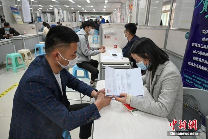 4月14日，招聘者在查看求職者簡(jiǎn)歷。<a target='_blank'  data-cke-saved- >中新社</a>記者 王剛 攝