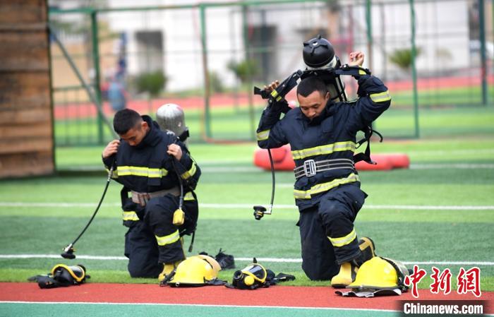 新消防員進(jìn)行穿戴空呼器展示?！⒅铱?攝