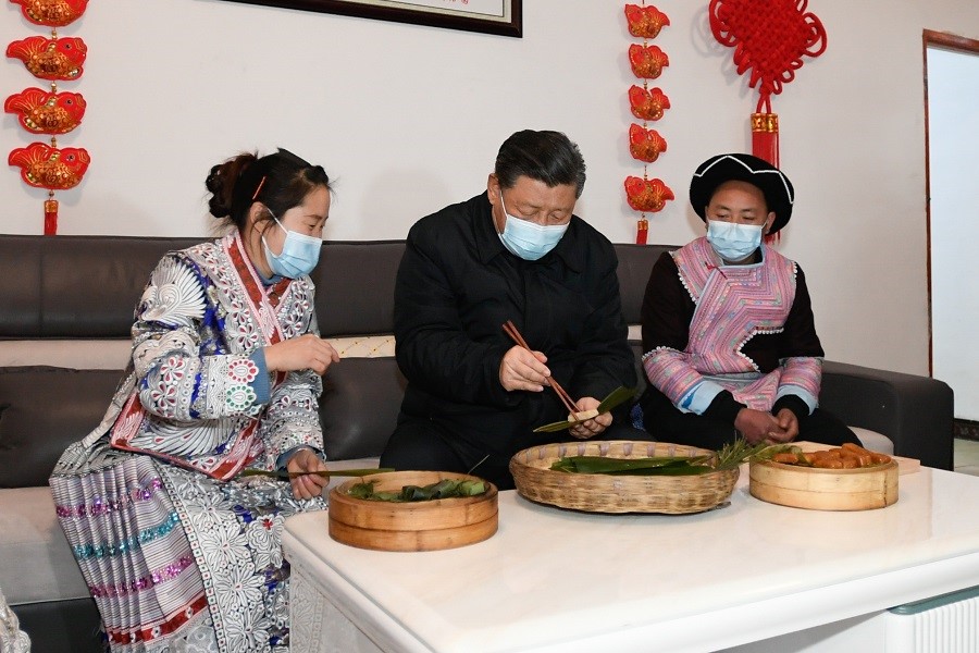 2021年2月3日下午，習(xí)近平在貴州畢節(jié)市黔西縣新仁苗族鄉(xiāng)化屋村苗族村民趙玉學(xué)家，同一家人邊聊家常邊制作當(dāng)?shù)貍鹘y(tǒng)節(jié)日食品黃粑。新華社記者 李學(xué)仁 攝